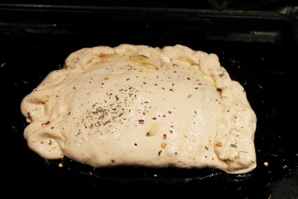 Sprinkle favorite herbs and spices over top homemade calzone before baking