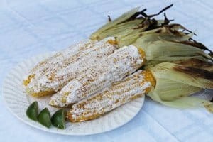 elotes, mexican corn on the cob with sour cream, parmesan, chili powder, and lime