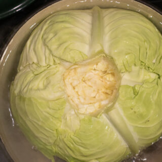 cabbage with core removed in pot of boiling water